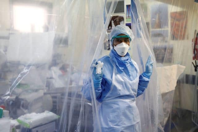 Medical staff, wearing protective suits and face masks, treat a patient suffering from coronavirus disease (COVID-19) in an intensive care unit at the Franco-Britannique hospital in Levallois-Perret near Paris as the spread of the coronavirus disease continues in France, April 15, 2020. REUTERS/Benoit Tessier