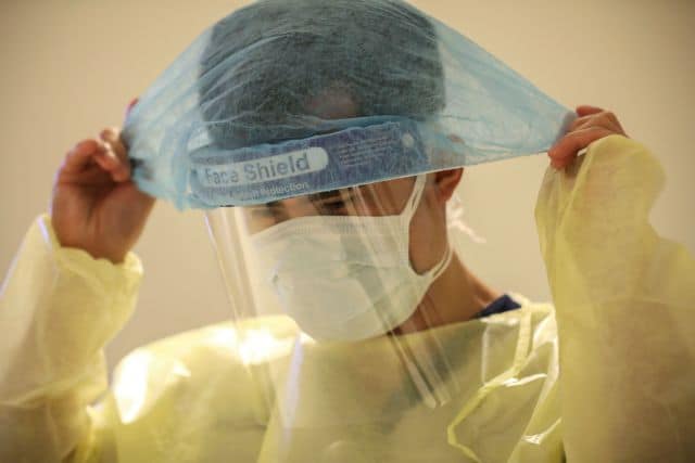 A member of medical staff puts on protective equipment in the intensive care unit (ICU), amid the coronavirus disease (COVID-19) outbreak, at the Cleveland Clinic hospital in Abu Dhabi, United Arab Emirates, April 20, 2020. REUTERS/Christopher Pike