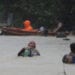 A man uses plastic containers to keep himself afloat as he crosses flooded road in Marikina, Philippines, due to Typhoon Vamco on Thursday, Nov. 12, 2020. The typhoon swelled rivers and flooded low-lying areas as it passed over the storm-battered northeast Philippines, where rescuers were deployed early Thursday to help people flee the rising waters. (AP Photo/Aaron Favila)