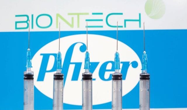 FILE PHOTO: Syringes are seen in front of displayed Biontech and Pfizer logos in this illustration taken November 10, 2020. REUTERS/Dado Ruvic/Illustration/File Photo