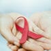 red aids ribbon in hand. soft focus on ribbon