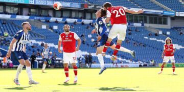 Arsenal's Shkodran Mustafi heads at goal under a challenge from Brighton & Hove Albion's Solly March as play resumes behind closed doors following the outbreak of the coronavirus disease (COVID-19) during the Premier League match between Brighton & Hove Albion and Arsenal, at The American Express Community Stadium, in Brighton, Britain, on June 20, 2020. Photo: Gareth Fuller/Pool via Reuters