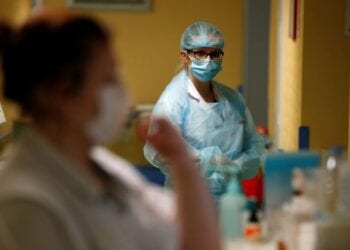 Nurses, wearing protective masks and protective suits, work in a Covid-19 medicine unit where patients suffering from the coronavirus disease (COVID-19) are treated at the Bethune-Beuvry hospital in Beuvry, France, October 16, 2020. REUTERS/Pascal Rossignol