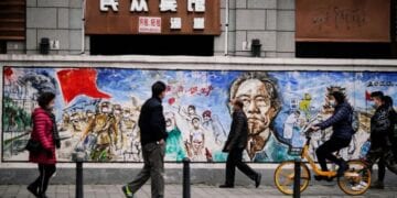 People wearing face masks walk on a street almost a year after the global outbreak of the coronavirus disease (COVID-19) in Wuhan, Hubei province, China December 7, 2020. Picture taken December 7, 2020. REUTERS/Aly Song