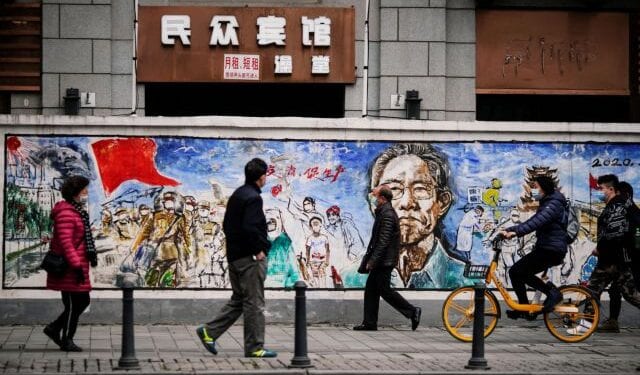 People wearing face masks walk on a street almost a year after the global outbreak of the coronavirus disease (COVID-19) in Wuhan, Hubei province, China December 7, 2020. Picture taken December 7, 2020. REUTERS/Aly Song