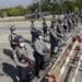 Policemen wearing protective face mask stand guard behind a road barricade, as a part of security preparations ahead of next week's opening of Myanmar's parliament in Naypyitaw, Myanmar, Friday, Jan. 29, 2021. Myanmar's election commission rejected allegations by the military that fraud played a significant role in determining the outcome of November's elections, which delivered a landslide victory to Aung San Suu Kyi's ruling party.(AP Photo/Aung Shine Oo)