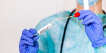 Lab technician holding swab collection kit,Coronavirus COVID-19 specimen collecting equipment,DNA nasal and oral swabbing for PCR polymerase chain reaction laboratory testing procedure and shipping